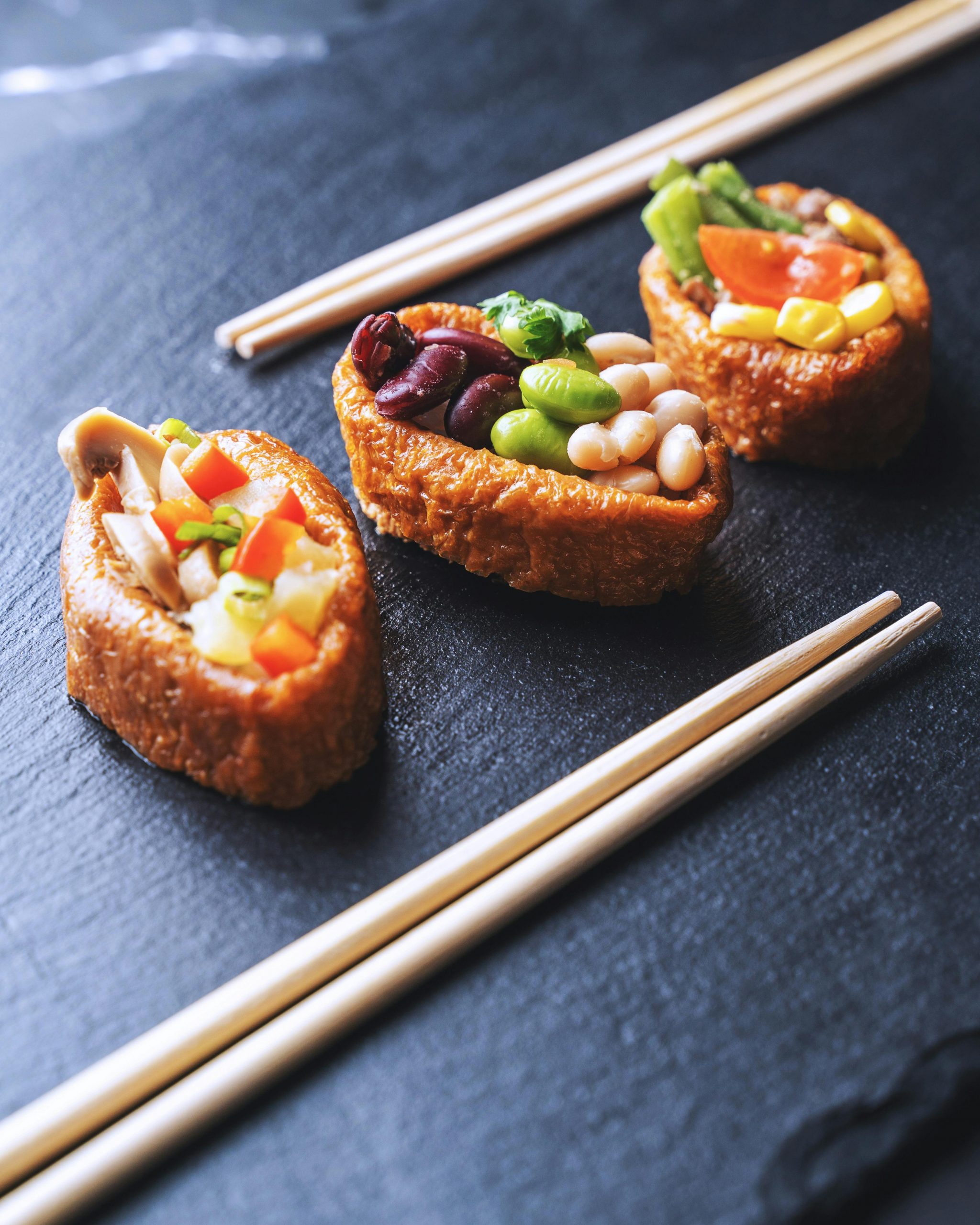 Creative sushi assortment with fresh vegetables on a slate board, showcasing a gourmet Japanese dining experience.